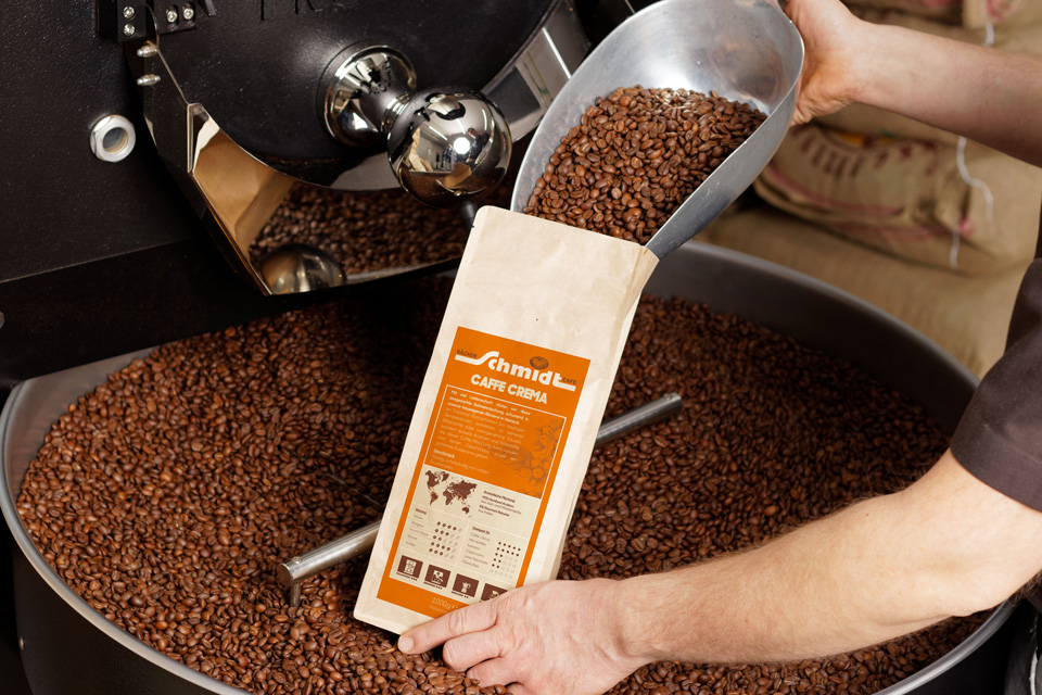 Person füllt Kaffeebohnen mit einem Portionierer in Verpackung