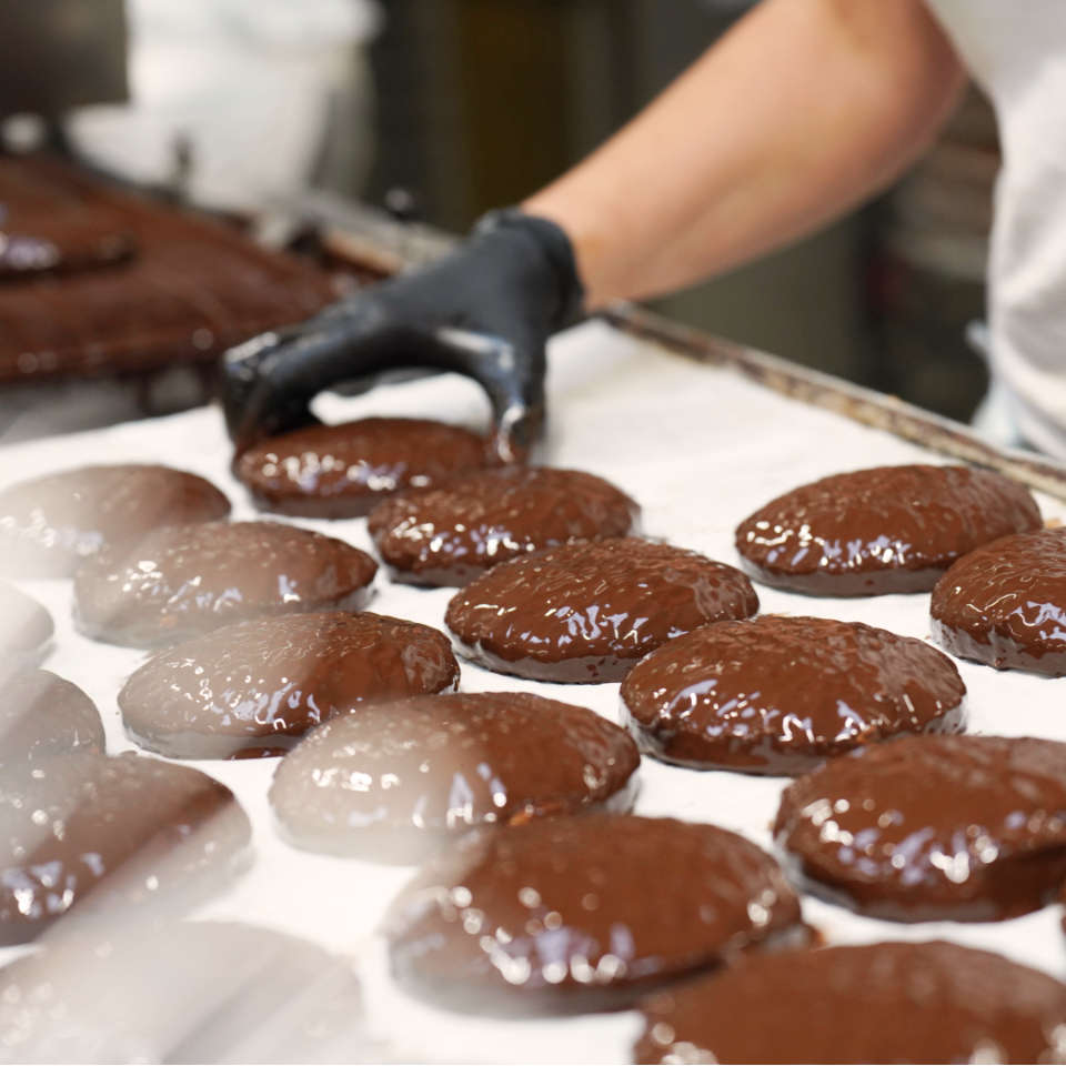 Die mit Schokolade überzogenen Elisenlebkuchen werden zum trocknen auf einem Tablett platziert