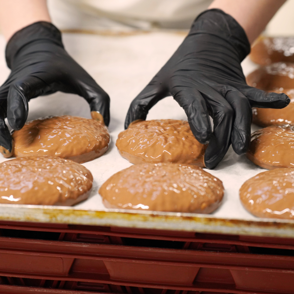 Die mit Vollmilch Pralinenschokolade glasierten Elisenlebkuchen werden zum Trocknen auf einem Tablett platziert